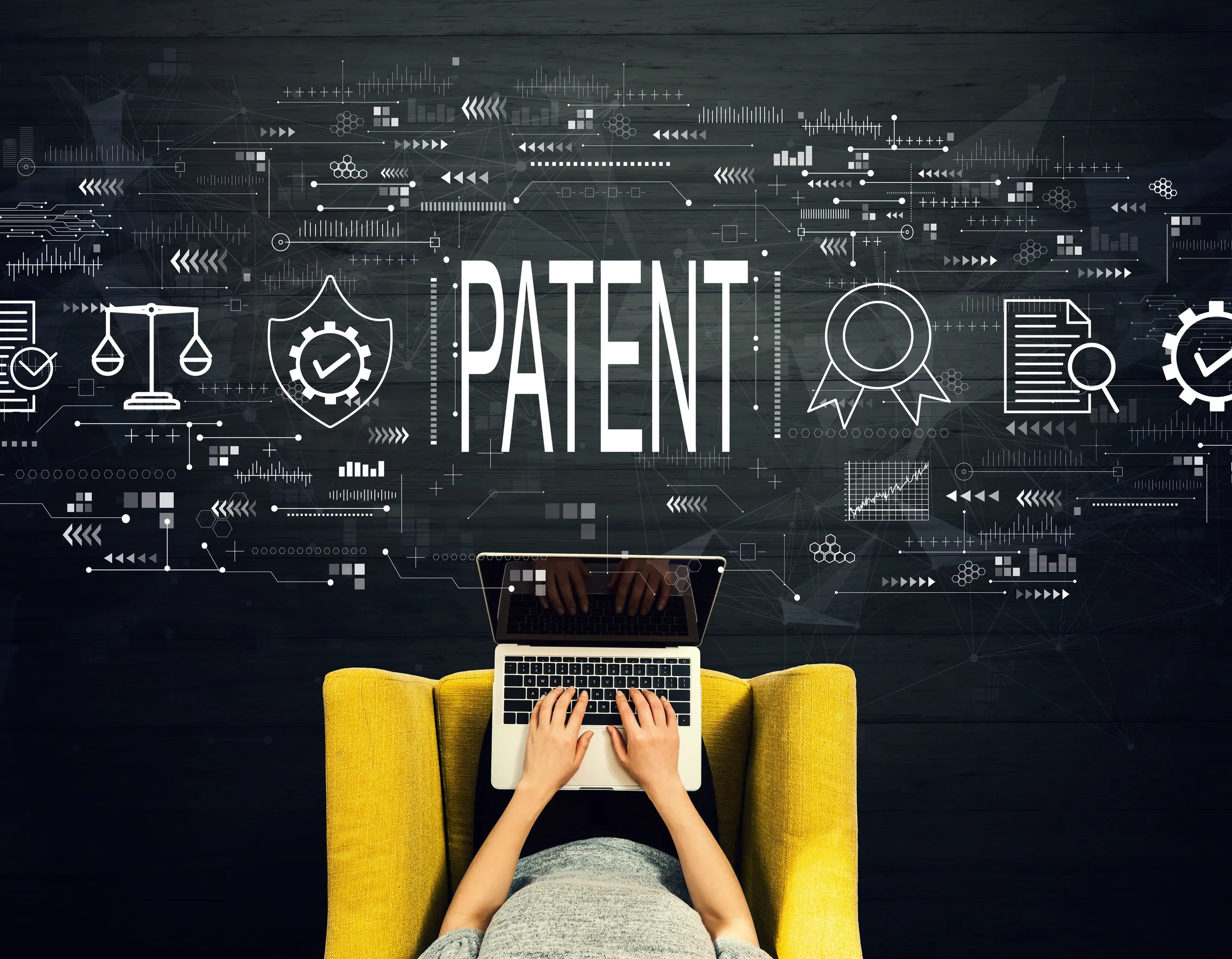 Person working on a laptop surrounded by patent and intellectual property icons